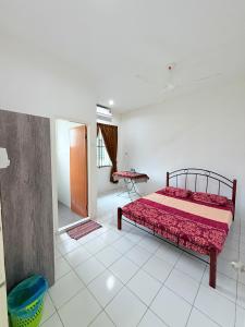 a bedroom with a bed and a table in it at KAA Homestay Bajet 2 in Tawau