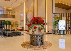 eine Lobby mit einem Tisch, auf dem rote Blumen stehen in der Unterkunft First Grand Hotel in Dammam