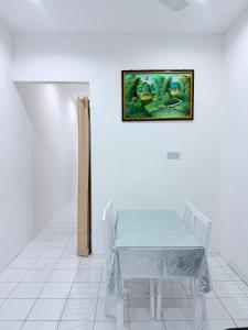 a table in a room with a picture on the wall at KAA Homestay Bajet 2 in Tawau