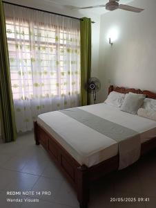 une chambre avec un lit et une fenêtre avec des rideaux dans l'établissement Serviced furnished rooms near Cinemax Nyali B6, à Mombasa