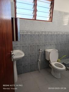 une salle de bains avec toilettes et lavabo dans l'établissement Serviced furnished rooms near Cinemax Nyali B6, à Mombasa