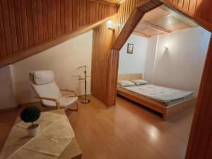 a bedroom with a bed and a chair in a room at Sunny Apartment in Predeal