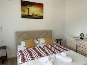 a bedroom with a large bed with towels on it at Apartment Himare Livadhe in Himare +8 photos