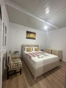 a bedroom with a large bed and a chair at Apartment Himare Livadhe in Himare