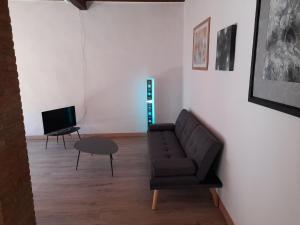 a living room with a couch and a television at Le 3 Finestre in Peccioli