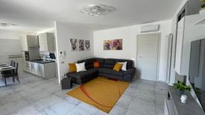 a living room with a black couch and a kitchen at La casa di Francy B&B in Bracigliano