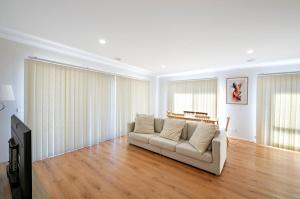 a living room with a couch and a tv at MV-Giraffe 4 bedroom x 3 bathroom in Hamilton +1 photo
