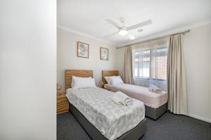 a bedroom with two beds and a window at MV-Giraffe 4 bedroom x 3 bathroom in Hamilton
