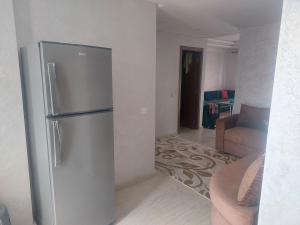穆罕默迪耶Très joli appartement vue sur parc 5 min de la plage du centre mohammedia的房间里有带不锈钢冰箱的厨房