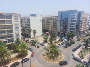 穆罕默迪耶Très joli appartement vue sur parc 5 min de la plage du centre mohammedia的棕榈树和汽车的城市鸟瞰图