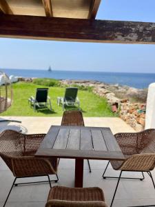 a wooden table and chairs with a view of the ocean at Villa Calma in Cala'n Bosch