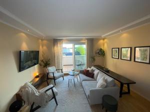 a living room with a white couch and a piano at Charming central penthouse with big terrace in Oslo