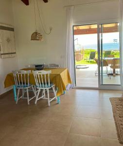 a dining room with a table and chairs and the ocean at Villa Calma in Cala'n Bosch +13 photos