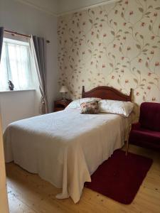 a bedroom with a bed and a red chair at Lock-house, Blackwatertown, UK in Blackwatertown