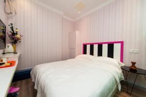 汉阳Weiyi Boutique House的一间卧室配有一张带粉红色床头板的大床
