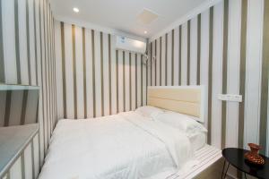 汉阳Weiyi Boutique House的卧室配有白色的床和条纹墙 更多3张照片