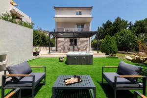 a backyard with two chairs and a table and a grill at Diverso Inn in Koskinou