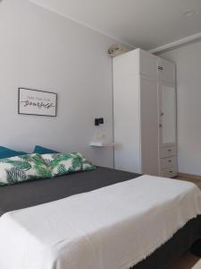 a white bedroom with a bed and a white cabinet at Apartamento Salgueiro ORTIGUEIRA in Santa Marta de Ortigueira
