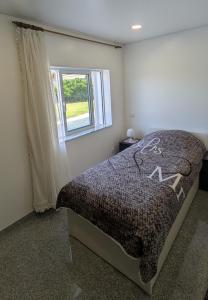 a bedroom with a bed and a window at Room Villa Ribeiro pilgrims way to SANTIAGO bike a garage for Marinhas Esposende in Esposende