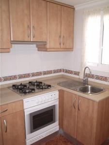 eine Küche mit Herd und Spüle in der Unterkunft Apartamento con vistas al mar in Piles