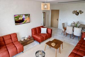 a living room with red furniture and a table at Zen garden by sea in Aïn Harrouda