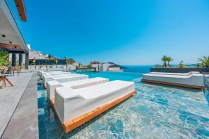 a pool with lounge chairs and the ocean in the background at Eco Villa Supernova in Kalkan