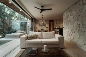 a living room with a couch and a ceiling fan at Ka'ana Condo in Tulum