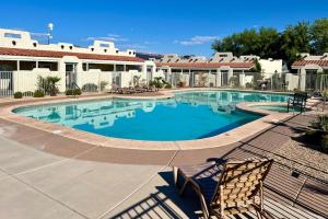 a large swimming pool with two chairs in front of a house at St. George Resort Condo in St. George