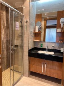 Un baño con ducha de cristal y lavabo. en Hotel Bukhara, en Bukhara