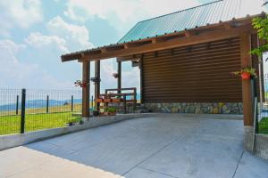a wooden pavilion with a fence in the background at Mountain Viewpoint in Žabljak