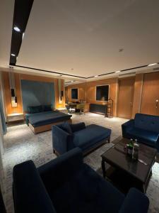 Una gran sala de estar con sofás y un televisor. en Hotel Bukhara, en Bukhara