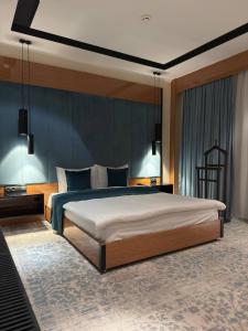 Un dormitorio con una cama grande y una pared azul. en Hotel Bukhara, en Bukhara 68 fotos más
