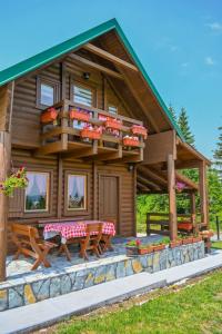 a log cabin with a deck and picnic tables at Mountain Viewpoint in Žabljak