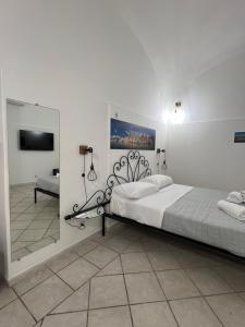 a bedroom with a large bed and a mirror at La casa del postino in Procida