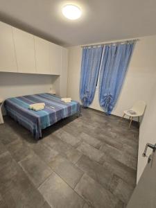 a bedroom with a bed and blue curtains at Le Dune di Quarzo in Càbras
