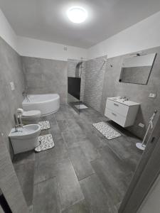 a bathroom with a toilet and a tub and a sink at Le Dune di Quarzo in Càbras +2 photos