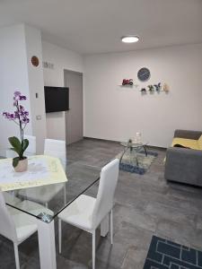 a living room with a table and chairs and a couch at Le Dune di Quarzo in Càbras