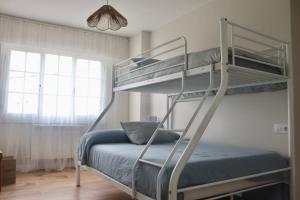a bedroom with two bunk beds with a blue bed at Apartamento Jañota en la Costa da Morte in Buño