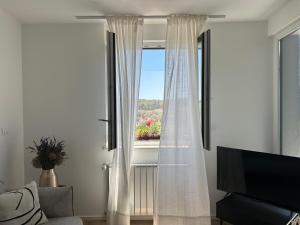 プーラにあるFiorea Apartmentのリビングルーム(白いカーテン付きの窓付)