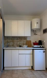 a kitchen with white cabinets and a white refrigerator at Hera's Hideaway in Samos