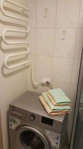 - une buanderie avec un lave-linge et des serviettes dans l'établissement Akropolis Studio, à Klaipėda