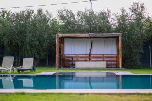 a swimming pool with two chairs and a pavilion at Oléa villa & lodge in Marrakesh