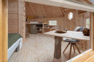 a wooden cabin with a table and a kitchen at kotaventure Famille in Le Mesnil-Villement