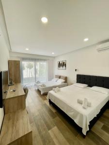 ein großes Schlafzimmer mit zwei Betten und einem Fernseher in der Unterkunft Square Residence & Pool in Ulcinj + 45 Fotos