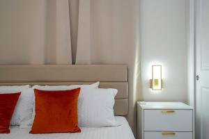 a bed with an orange pillow and a night stand at Modern and Spacious 5BR Villa Near Disney with Private Pool and Themed Bedrooms in Orlando