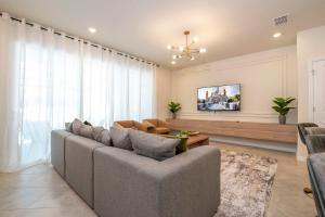 a living room with a couch and a tv at Modern and Spacious 5BR Villa Near Disney with Private Pool and Themed Bedrooms in Orlando