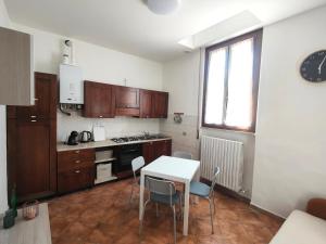a kitchen with a table and chairs and a window at Oltrepo' Guest House in Voghera