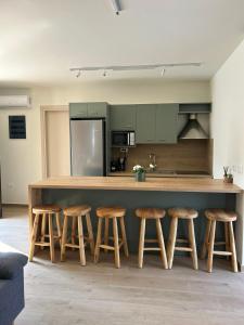 a kitchen with a large wooden counter with stools at Alestone Villa by the sea in Vasilikos