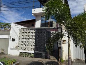 a white house with a palm tree in front of it at KIPFLATS Residence in Fortaleza