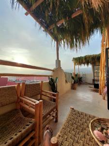 a living room with benches and a view of the ocean at Moroccan Boho Surf House in Agadir